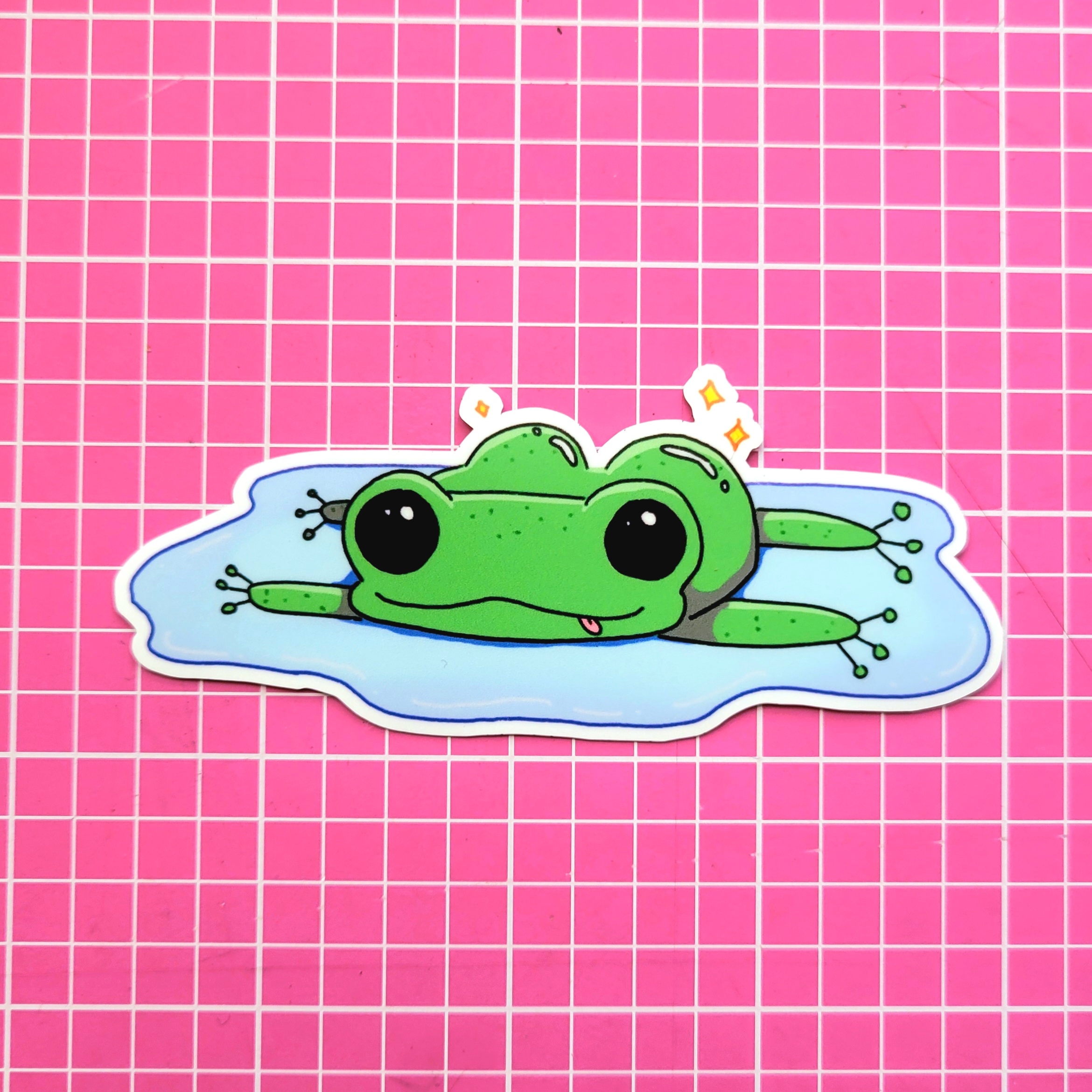 frog butt: A frog lying down on top of a puddle, sprawled out, butt out and shiny, tongue out silly style